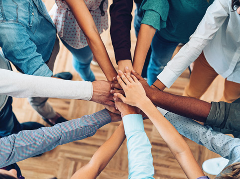 group of people stacking their hands in the middle