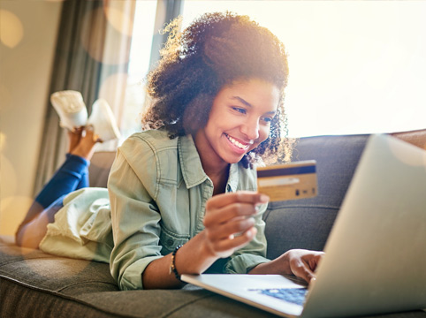 woman using a credit card while she shops online