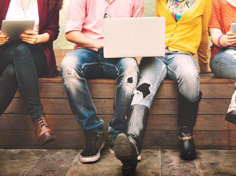 group of young people using smart devices together